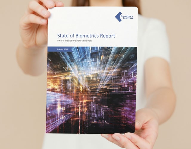 Woman holding a copy of the Biometrics Institute State of Biometrics Report